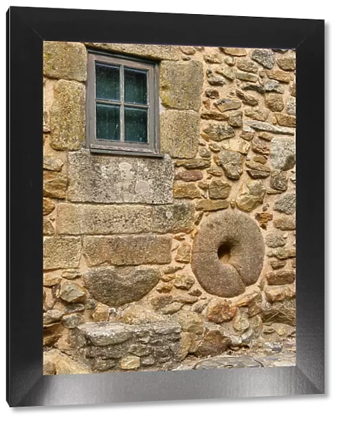 A millstone on the wall of a traditional house. Castelo Rodrigo, Beira Alta. Portugal