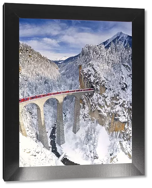 Bernina Express train on Landwasser viaduct during the snowy winter, Filisur