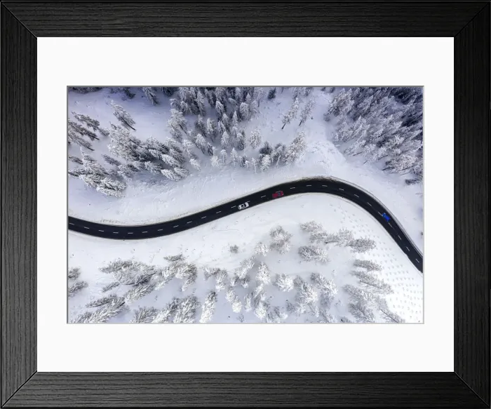 Framed Print : Aerial view of cars traveling on winding mountain road crossing the snow capped woods in Framed Print : Aerial view of cars traveling on winding mountain road crossing the snow capped woods in