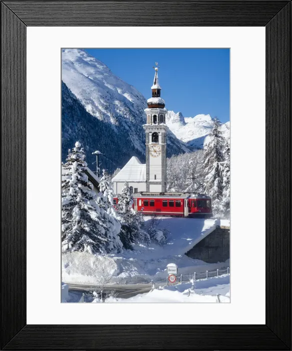 Framed Print : Winter sun over Bernina Express train and church bell tower of Bever village covered with Framed Print : Winter sun over Bernina Express train and church bell tower of Bever village covered with