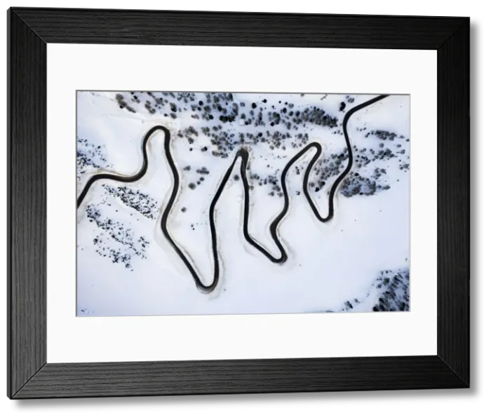 Framed Print : Narrow bends of icy road along the snow capped mountain pass from above, Dolomites, Italy Framed Print : Narrow bends of icy road along the snow capped mountain pass from above, Dolomites, Italy