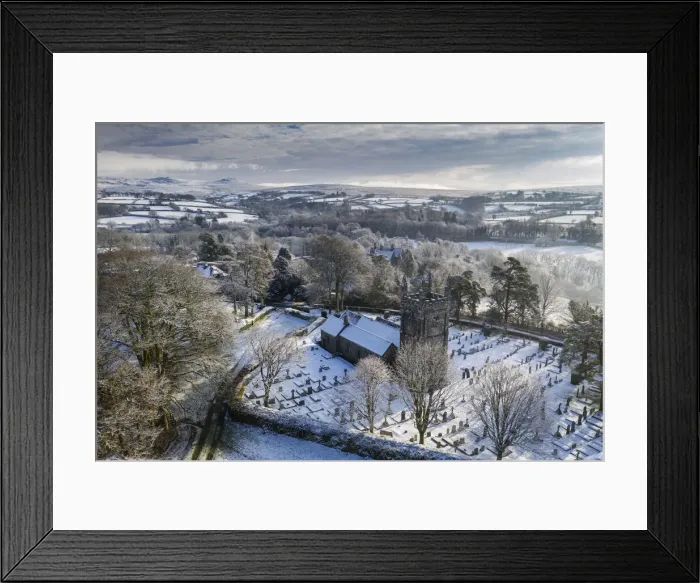 Framed Print : Aerial vista of St Petrocs Church on a snowy winter morning in the Dartmoor village of Framed Print : Aerial vista of St Petrocs Church on a snowy winter morning in the Dartmoor village of
