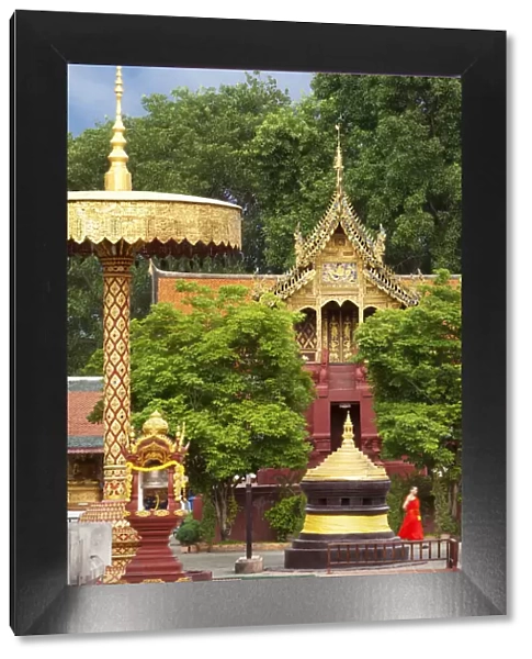 Thailand, Lamphun, Wat Phrathat Haripunchai Woramahawihan, monk walking infront of temple