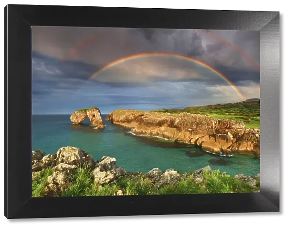 Cliff landscape with rock arch under rainbow - Spain, Asturias, Oriente, Ribadesella