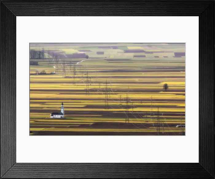 Framed Print : Church of St. Ursula, electricity pylons and arable field patterns, Ljubljana Basin Framed Print : Church of St. Ursula, electricity pylons and arable field patterns, Ljubljana Basin
