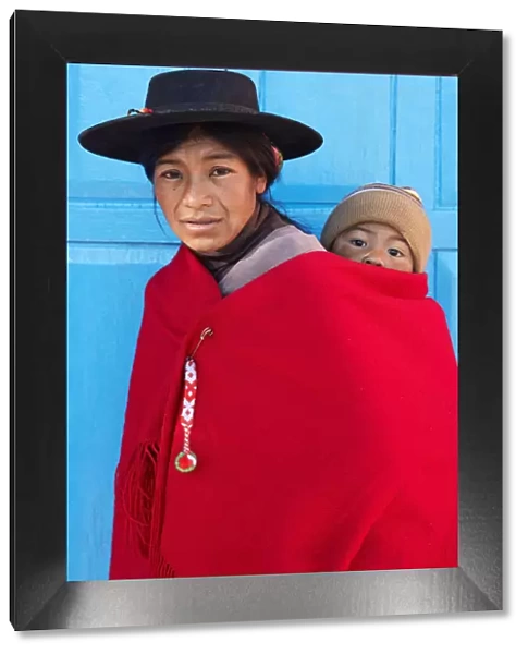 Portrait of an Aymara mother in traditional clothes with her child standing in front of