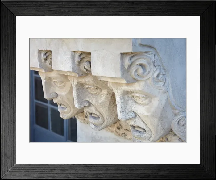 Framed Print : Detail of faces carved on the exterior facade of the historic Framed Print : Detail of faces carved on the exterior facade of the historic