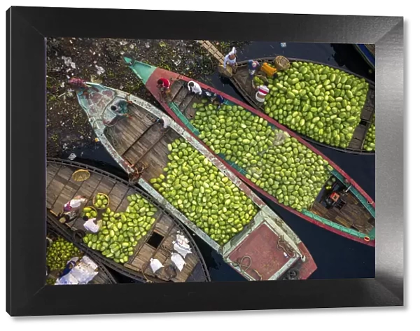 Aerial view of several small commercial boats with people unloading watermelons at Old