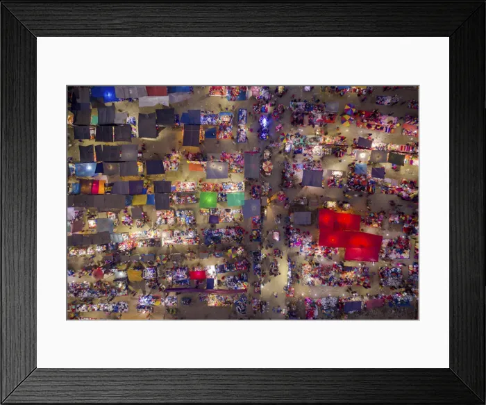 Framed Print : Night aerial view of people trading at weekly market, seeking out products in the city of Framed Print : Night aerial view of people trading at weekly market, seeking out products in the city of