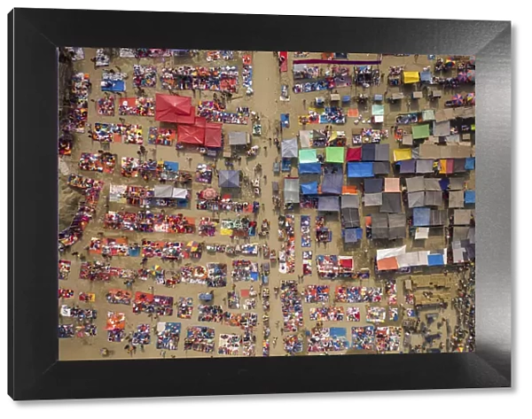 Aerial view of people trading at weekly market, seeking out products in the city of