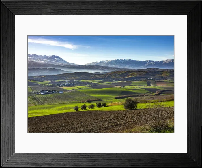 Framed Print : Cultivated fields and small villages. In the background Framed Print : Cultivated fields and small villages. In the background