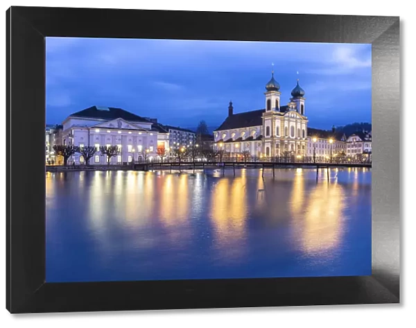 View of the Jesuit Church and the old town of Lucerne at blue hour reflected on the Reuss