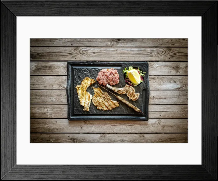 Framed Print : Mixed grilled meat in black tray on rustic wood table background from above, Italy Framed Print : Mixed grilled meat in black tray on rustic wood table background from above, Italy