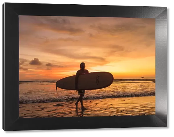 Surfer at Playa de Jaco at sunset, Jaco, Pacific coast, Puntarenas, Costa Rica