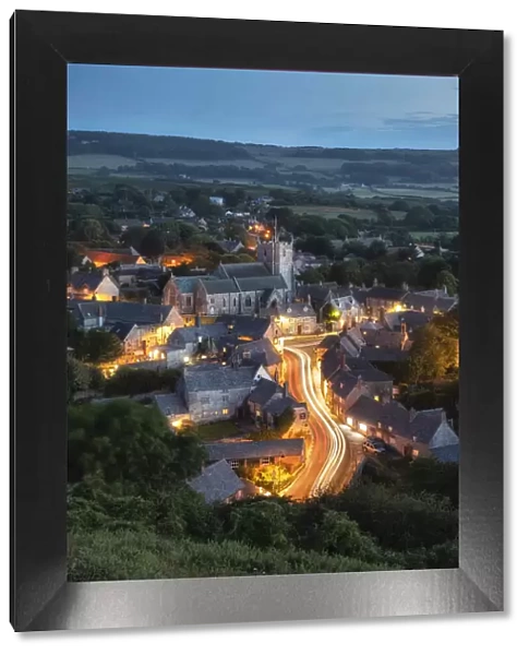 Corfe Castle village at dusk viewed from East Hill, Dorset, England, UK