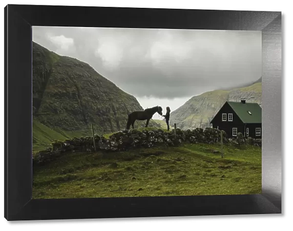 A Faroese girl with her horse in Saksun. Streymoy, Faroe Islands