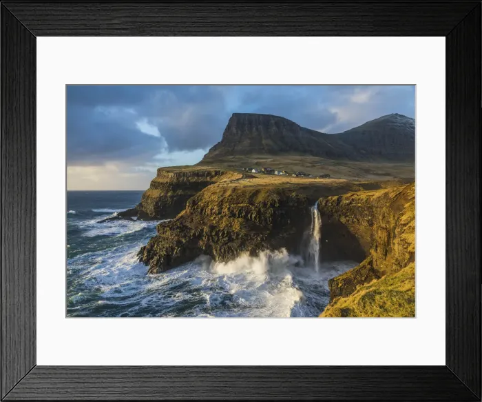 Framed Print : The village of Gasadalur and its waterfall, at sunset, while they are hit by strong winds. Vagar, Faroe Islands