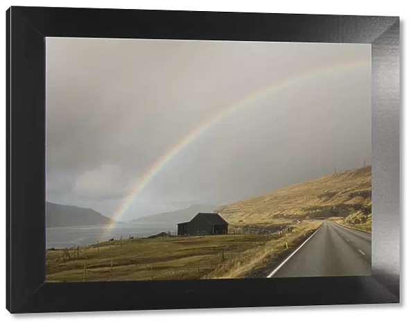 A rainbow over a sheep house on the Sundini strait between the islands of Eysturoy and Streymoy. Faroe Islands