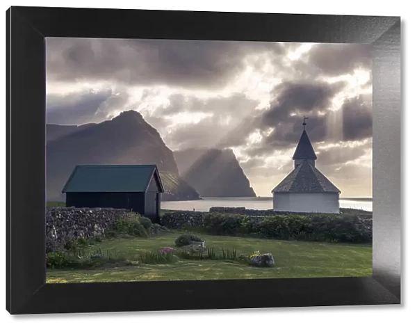 The church in Viðareiði (island of Viðoy). In the background the cliffs of the islands of Borðoy and Kunoy. Faroe Islands
