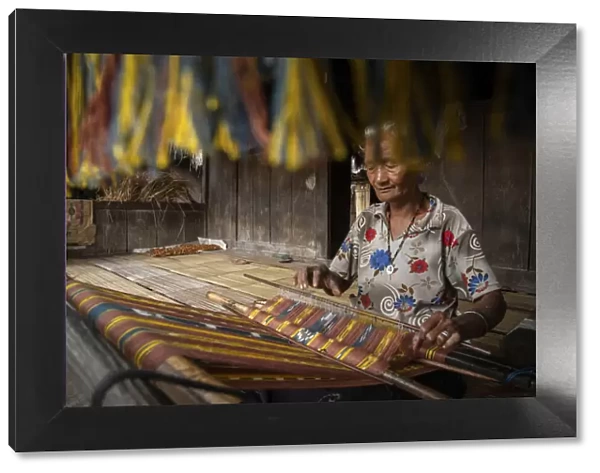 A woman in Bena village making woven fabrics called Tenun Ikat. Flores Island