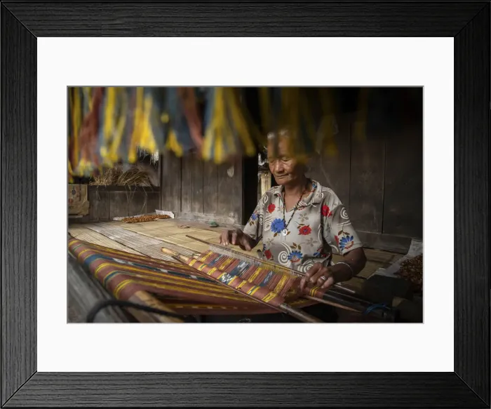 Framed Print : A woman in Bena village making woven fabrics called Tenun Ikat. Flores Island