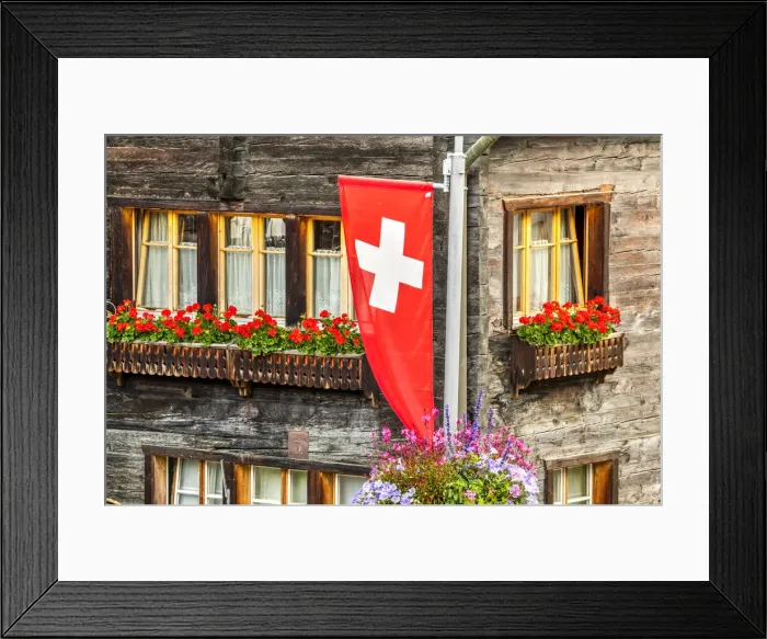 Framed Print : Swiss flag with typical wooden house decorated with flowers behind, Zermatt, Valais Framed Print : Swiss flag with typical wooden house decorated with flowers behind, Zermatt, Valais