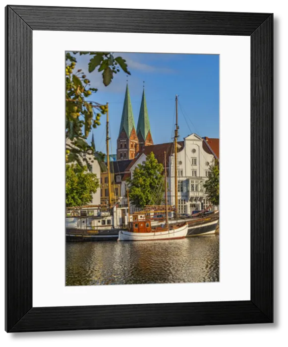 Framed Print : Fishing and tourism boats moored on the river Trave & the church of Santa Maria Framed Print : Fishing and tourism boats moored on the river Trave & the church of Santa Maria