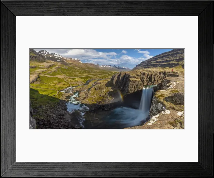 Framed Print : Person observes Folaldafoss waterfall and Berufjordur during summer, Austurland Framed Print : Person observes Folaldafoss waterfall and Berufjordur during summer, Austurland