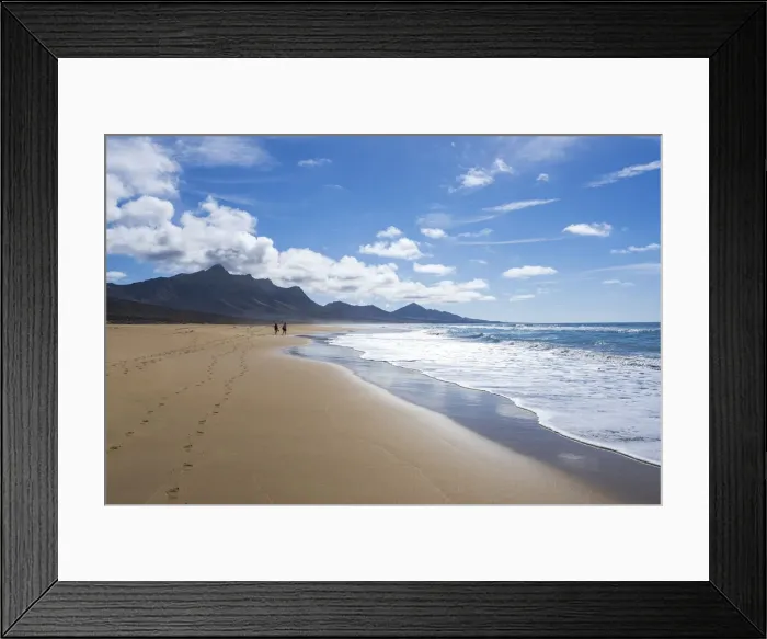 Framed Print : Man and woman walking on golden sand of Cofete beach washed by ocean waves, Jandia Framed Print : Man and woman walking on golden sand of Cofete beach washed by ocean waves, Jandia