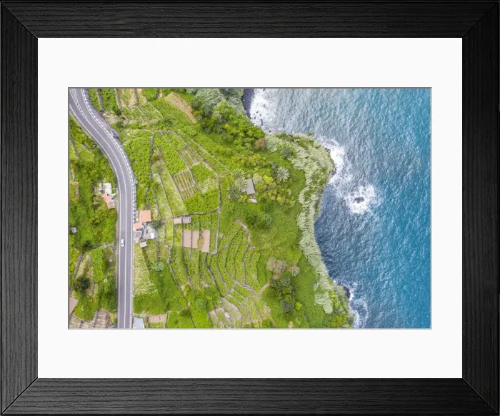 Framed Print : car on empty road crossing the lush green land by the ocean, Seixal, Madeira island Framed Print : car on empty road crossing the lush green land by the ocean, Seixal, Madeira island