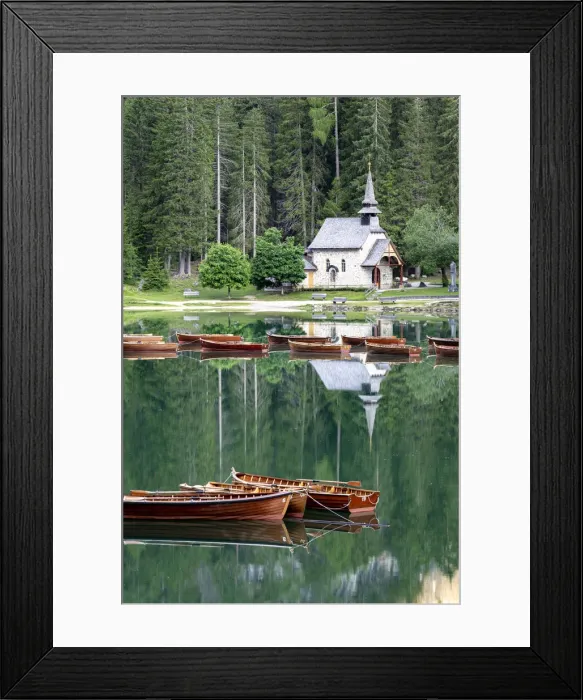 Framed Print : Boats moored in lake Braies (Pragser Wildsee) with small chapel and forest on background Framed Print : Boats moored in lake Braies (Pragser Wildsee) with small chapel and forest on background