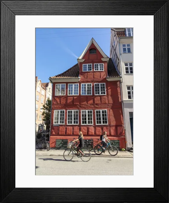 Framed Print : Cyclists pass an old red house in Central Copenhagen, Copenhagen, Denmark Framed Print : Cyclists pass an old red house in Central Copenhagen, Copenhagen, Denmark