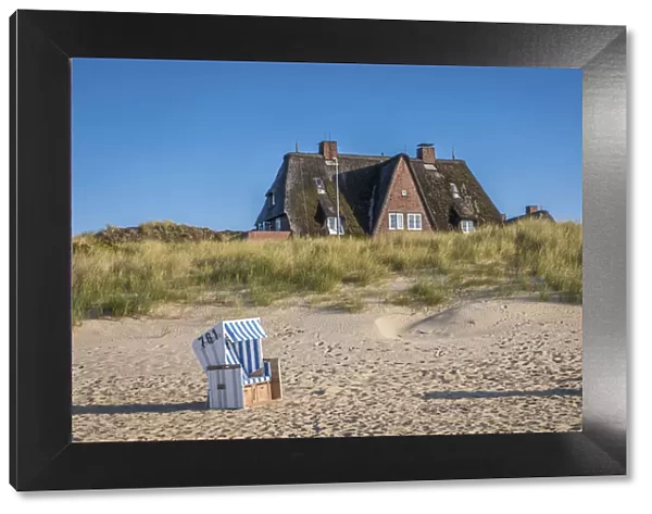 Beach chair and thatched roof house on the east beach of List, Sylt, Schleswig-Holstein