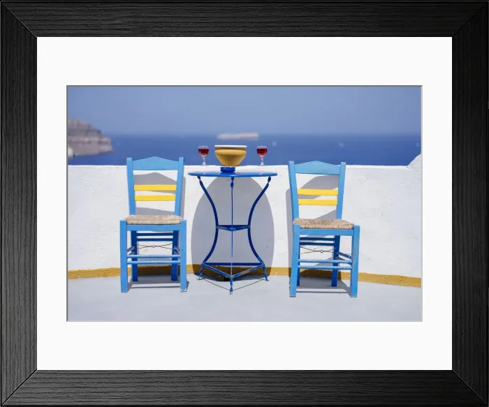 Framed Print : Chairs and table with two glasses of red wine against sea, Santorini, Cyclades Framed Print : Chairs and table with two glasses of red wine against sea, Santorini, Cyclades