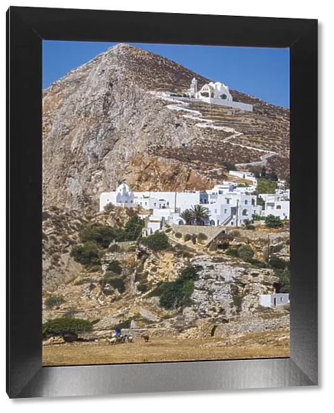 shepherd with goats and the Hora Village in Folegandros, Cyclades Islands, Greece
