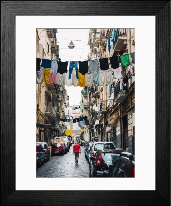 Framed Print : Man walks in an alley in Naples, with clothes hanging between the buildings Framed Print : Man walks in an alley in Naples, with clothes hanging between the buildings