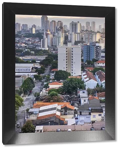 Brazil, Sao Paulo, Sao Paulo City, Vila da Saude, residental apartment block towers, low-rise suburban houses and a tree-lined street, no people