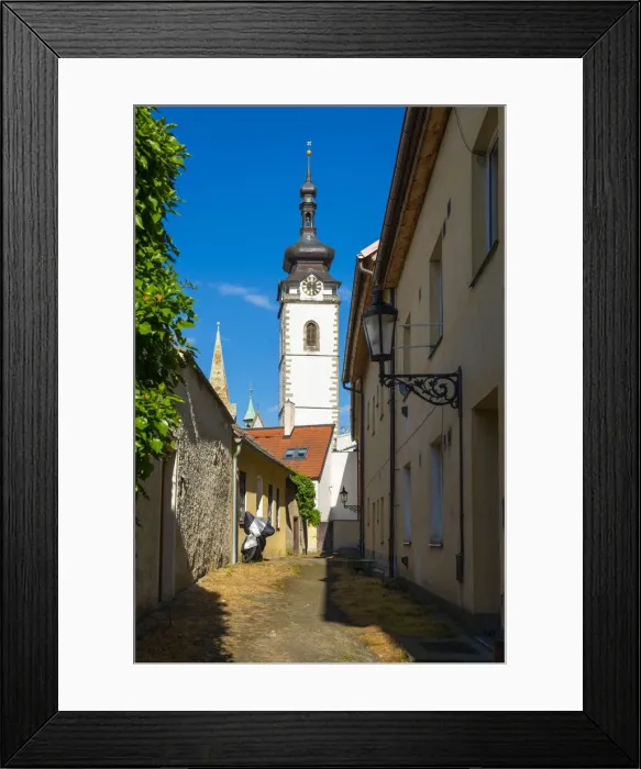 Framed Print : Lane towards tower of Church of the Nativity of the Blessed Virgin Mary on sunny day, Pisek, South Bohemian Region, Czech Republic Framed Print : Lane towards tower of Church of the Nativity of the Blessed Virgin Mary on sunny day, Pisek, South Bohemian Region, Czech Republic