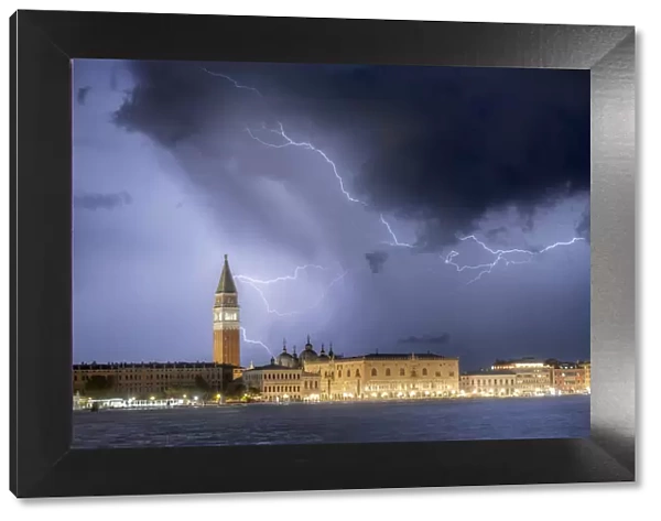 A stormy late summer night in Venice: pictured in the frame is St. Mark Square, with its tower and its palace, from the Giudecca island. Venice, Italy
