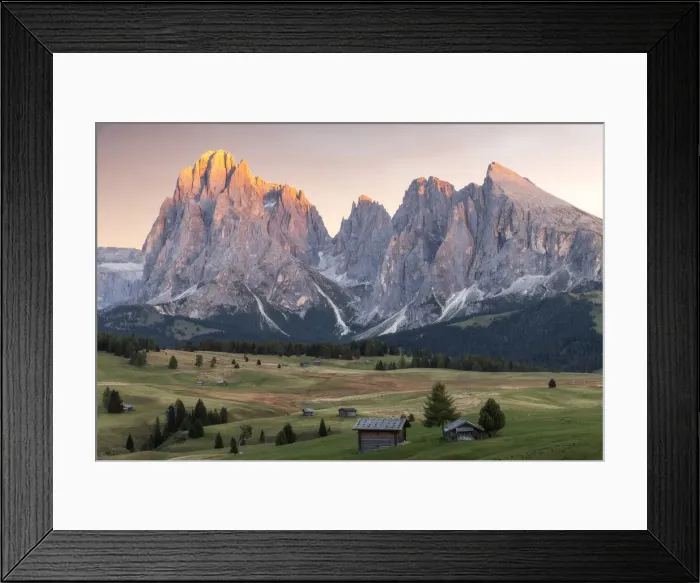 Framed Print : Lush green meadows and some old cabins create the classic alpine landscape at the Alpe di Siusi (Seiser Alm), with the Sassolungo and Sassopiatto taking the last light in the background. Dolomites, Italy Framed Print : Lush green meadows and some old cabins create the classic alpine landscape at the Alpe di Siusi (Seiser Alm), with the Sassolungo and Sassopiatto taking the last light in the background. Dolomites, Italy