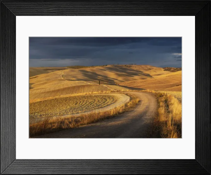 Framed Print : A winding road and rolling hills during a brief moment of light at sunset before the storm rolled in. Taken near Montalcino, Val d Orcia, Tuscany, Italy Framed Print : A winding road and rolling hills during a brief moment of light at sunset before the storm rolled in. Taken near Montalcino, Val d Orcia, Tuscany, Italy