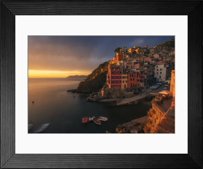Framed Print : A dramatic autumnal sunset in Riomaggiore, Cinque Terre, where the last light of the day hit the walls of the small fishermens village Framed Print : A dramatic autumnal sunset in Riomaggiore, Cinque Terre, where the last light of the day hit the walls of the small fishermens village
