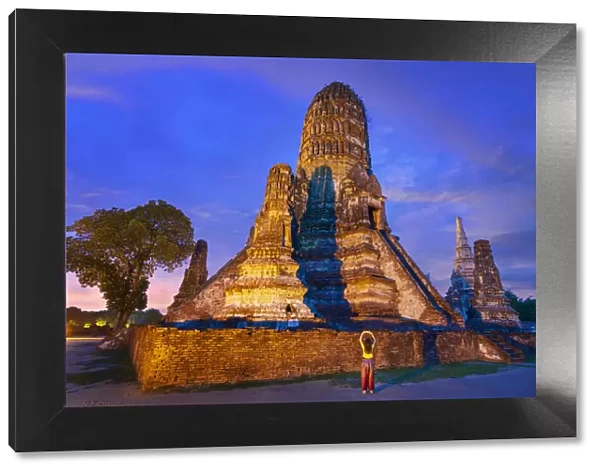 Thailand, Phra Nakhon Si Ayutthaya, Ayutthaya, Wat Chai Watthanaram illuminated at night, girl with camera. UNESCO World Heritage site (MR)