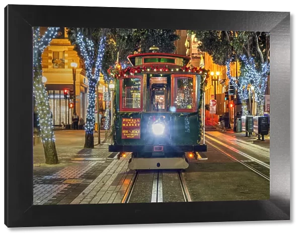 Powell and Market line cable car adorned with Christmas decorations by night, San Francisco, California, USA