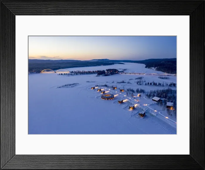 Framed Print : Illuminated floating circular building and wood cabins of Arctic Bath Hotel in the snow at dusk, Harads, Lapland, Sweden
