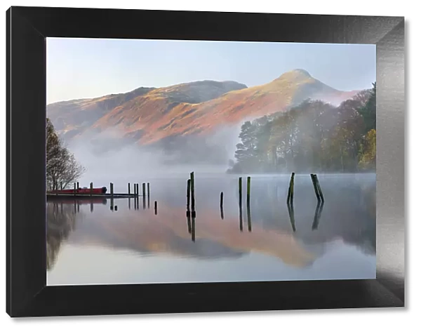 Early morning tranquil scenes of Derwent Water, with Catbells rising out of the mist in the background, Lake District National Park, Cumbria, England, UK. Autumn (November) 2009