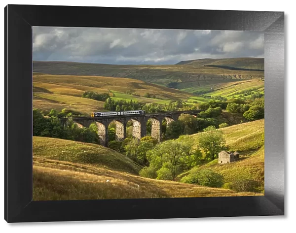 Northern Railway passenger train crossing Dent Head Viaduct in the Yorkshire Dales National Park, Yorkshire, England. Autumn (October) 2021