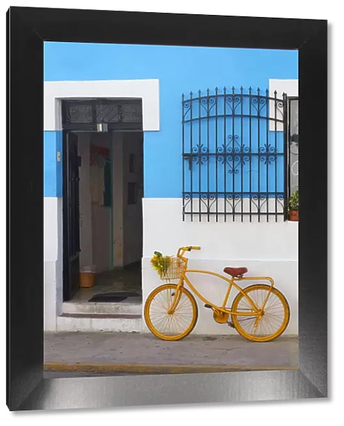 A yellow bike in front of a colorful shop in Merida, Yucatan, Mexico