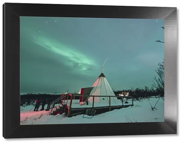 Swedish Lapland, Abisko National Park. Northern Lights over a typical teepee in the snow, winter. Arctic Circle