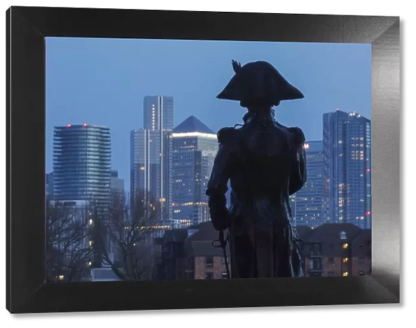 England, London, Greenwich, Silouette of Lord Nelson Statue and the Canary Wharf Skyline at Night
